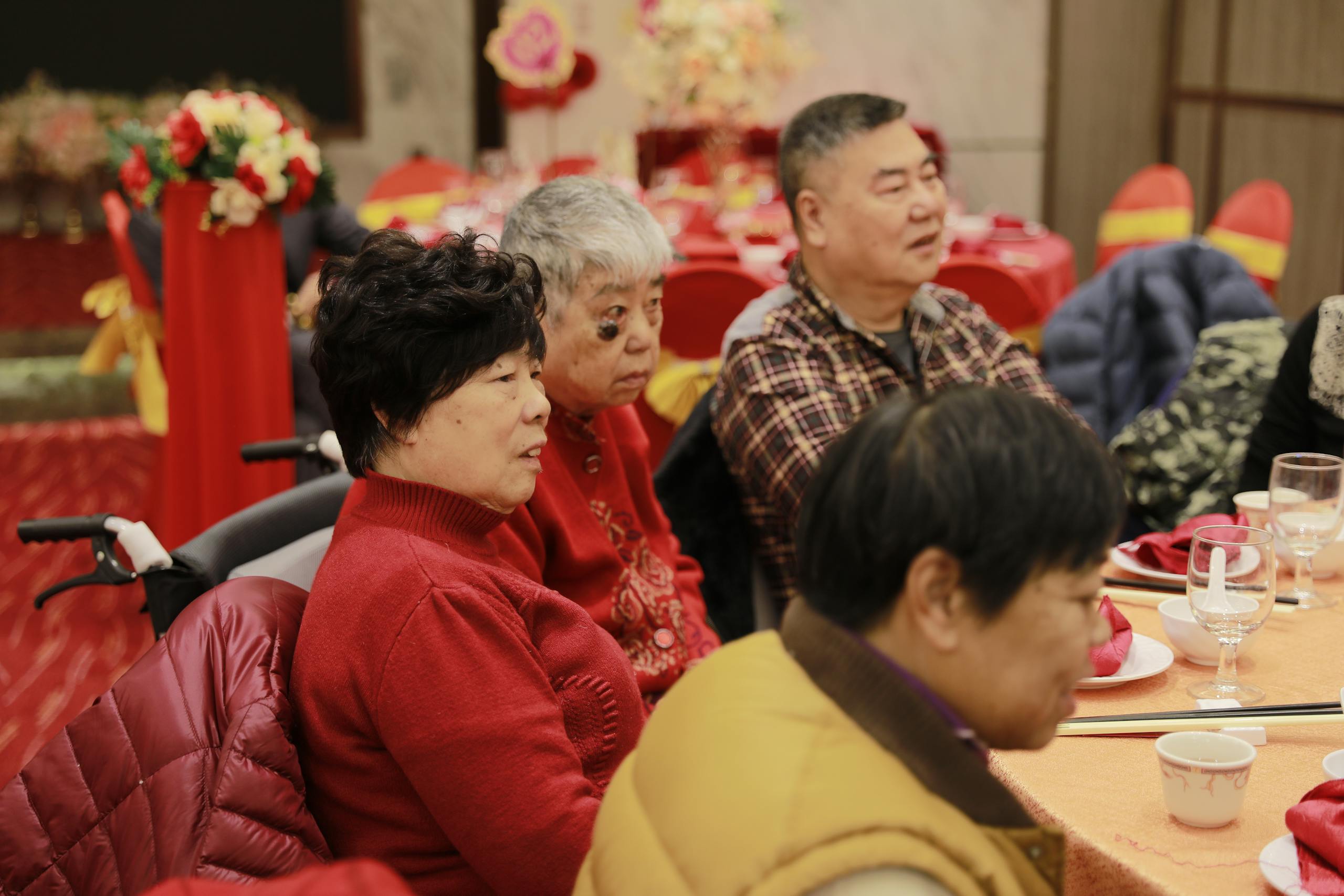 Asian family sitting together at a festively decorated dining table during a celebration.