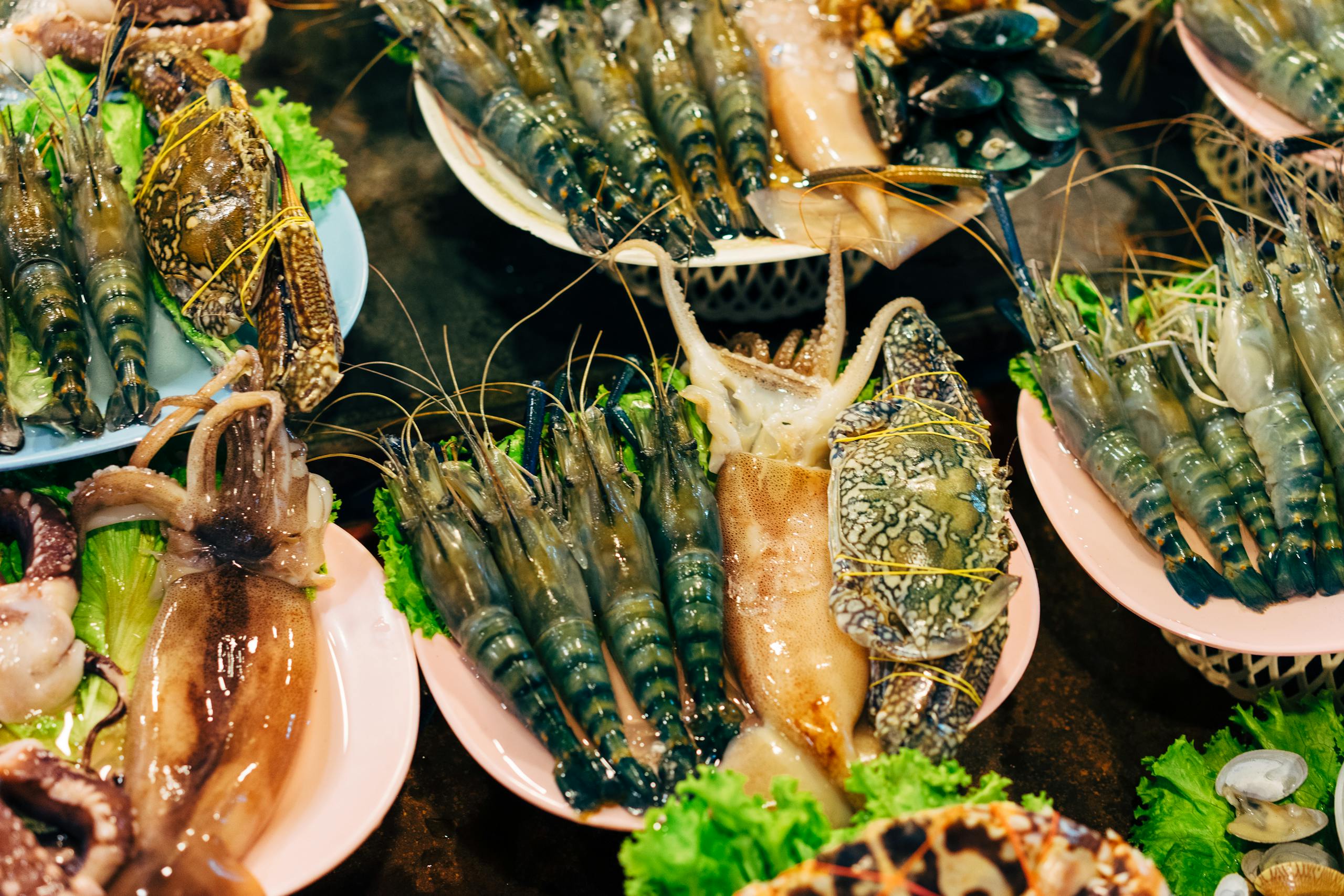 Assorted fresh seafood including prawns and shellfish on display at a market.