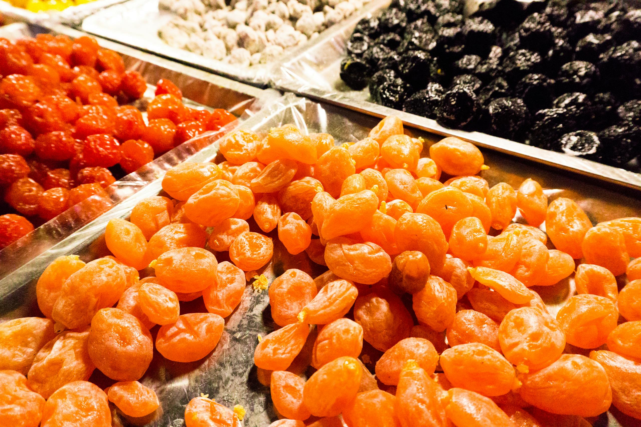 Vibrant selection of dried fruits including apricots and cherries, displayed at a market stall.