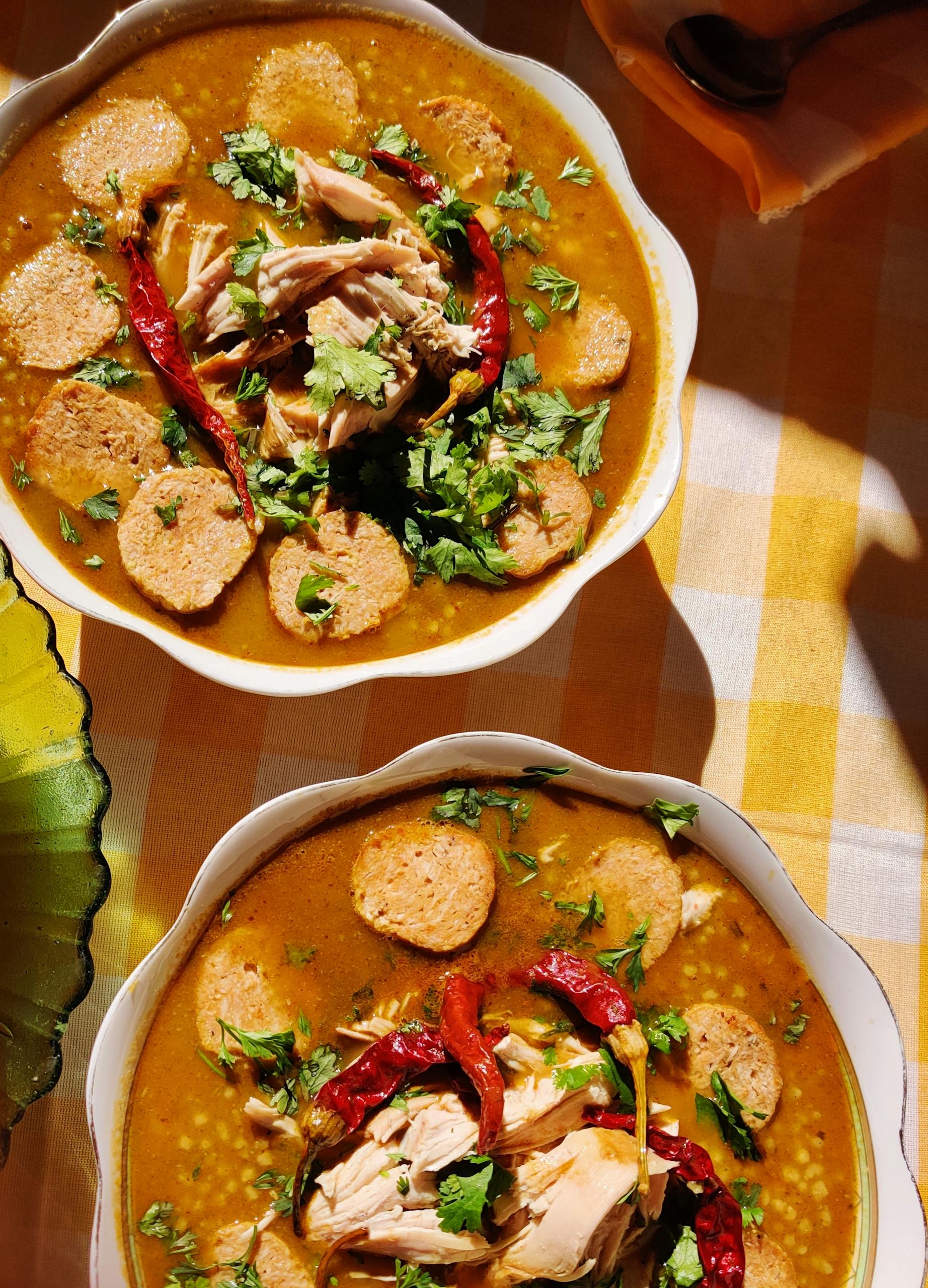 Warm, spicy soup garnished with chicken, red chilies, and fresh cilantro.