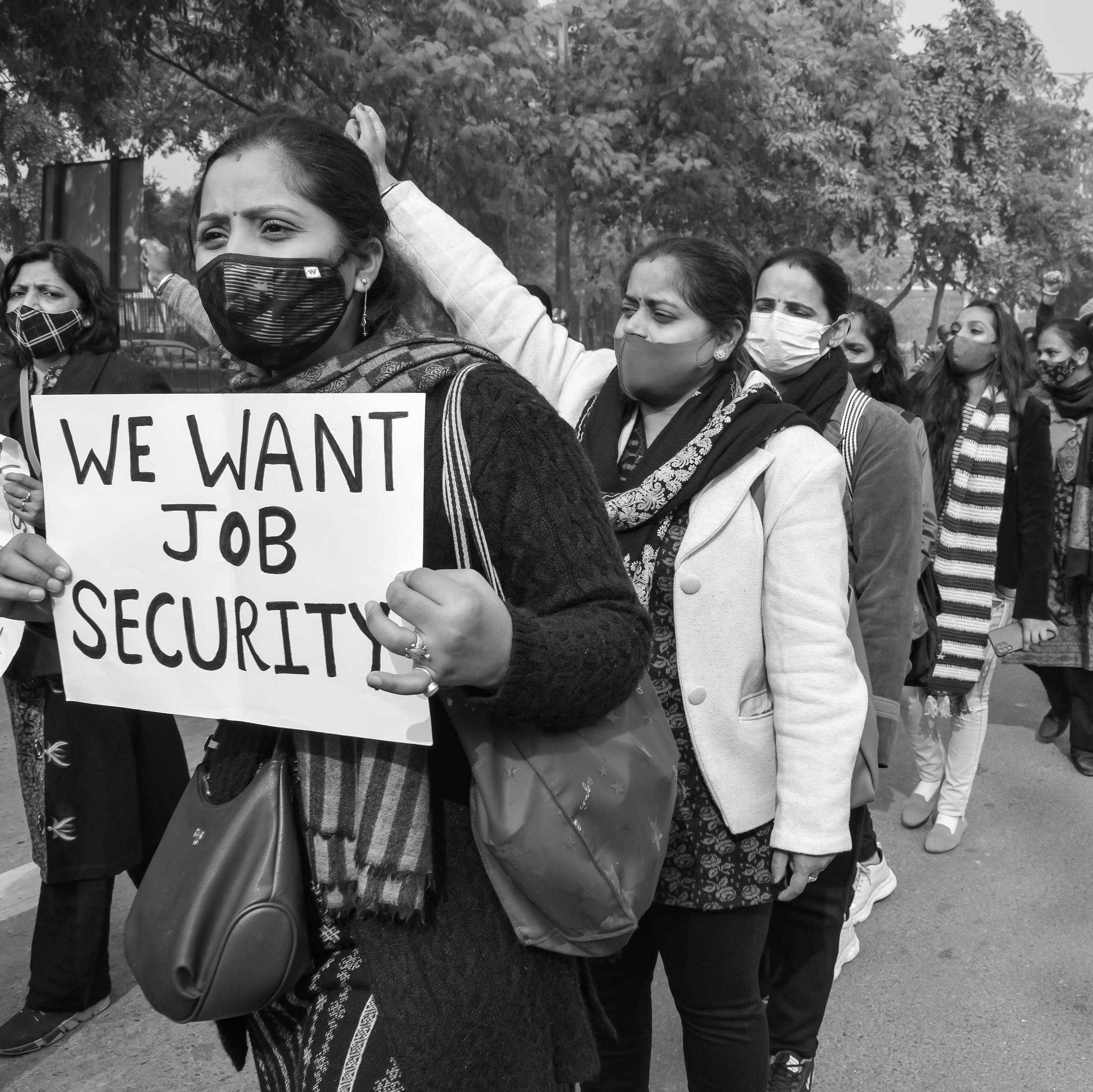 Black and white photo of women protesting for job security, showcasing peaceful activism and social justice.