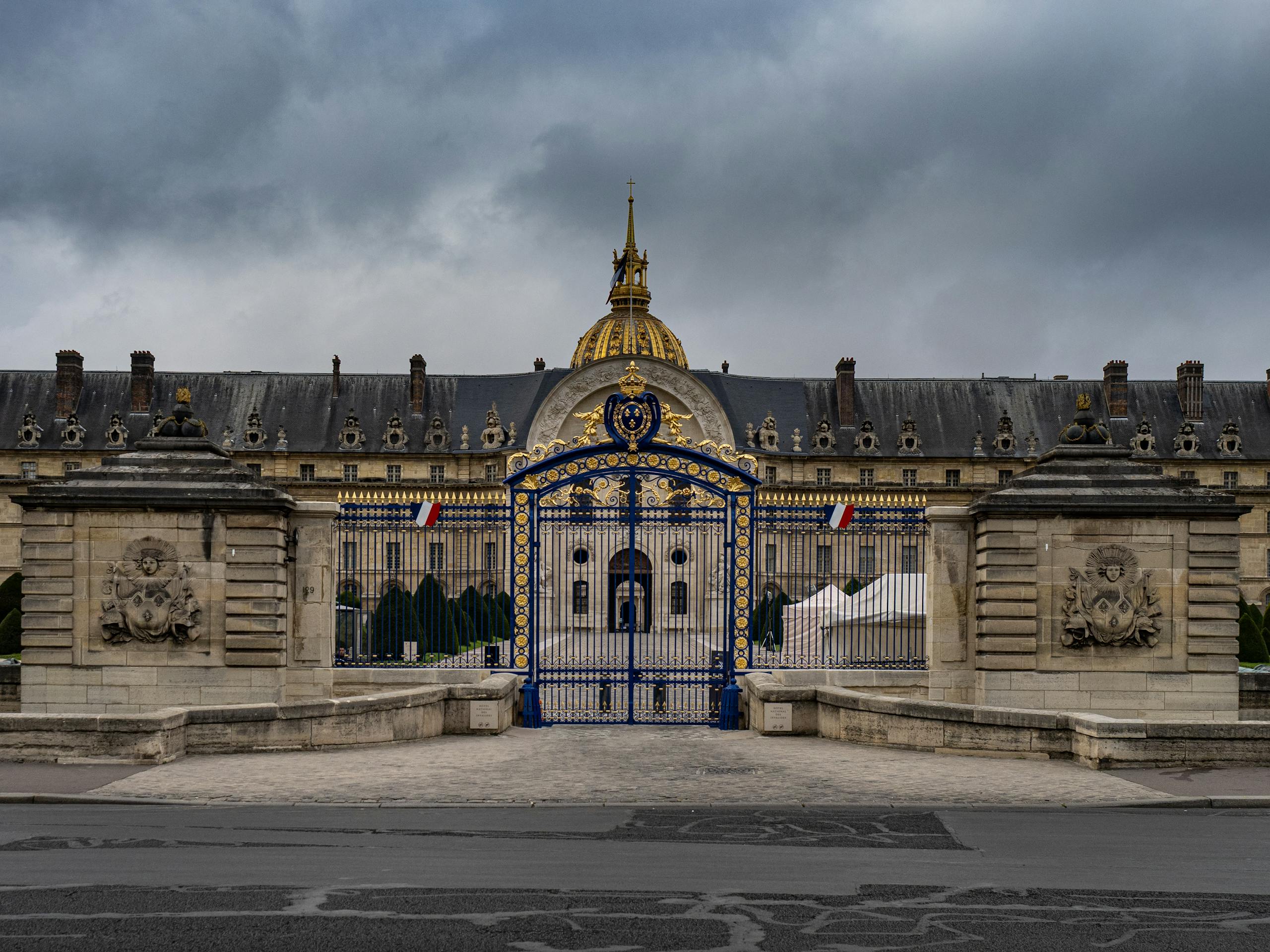 View of Les Invalides with its iconic golden dome and ornate gates in Paris, France.
