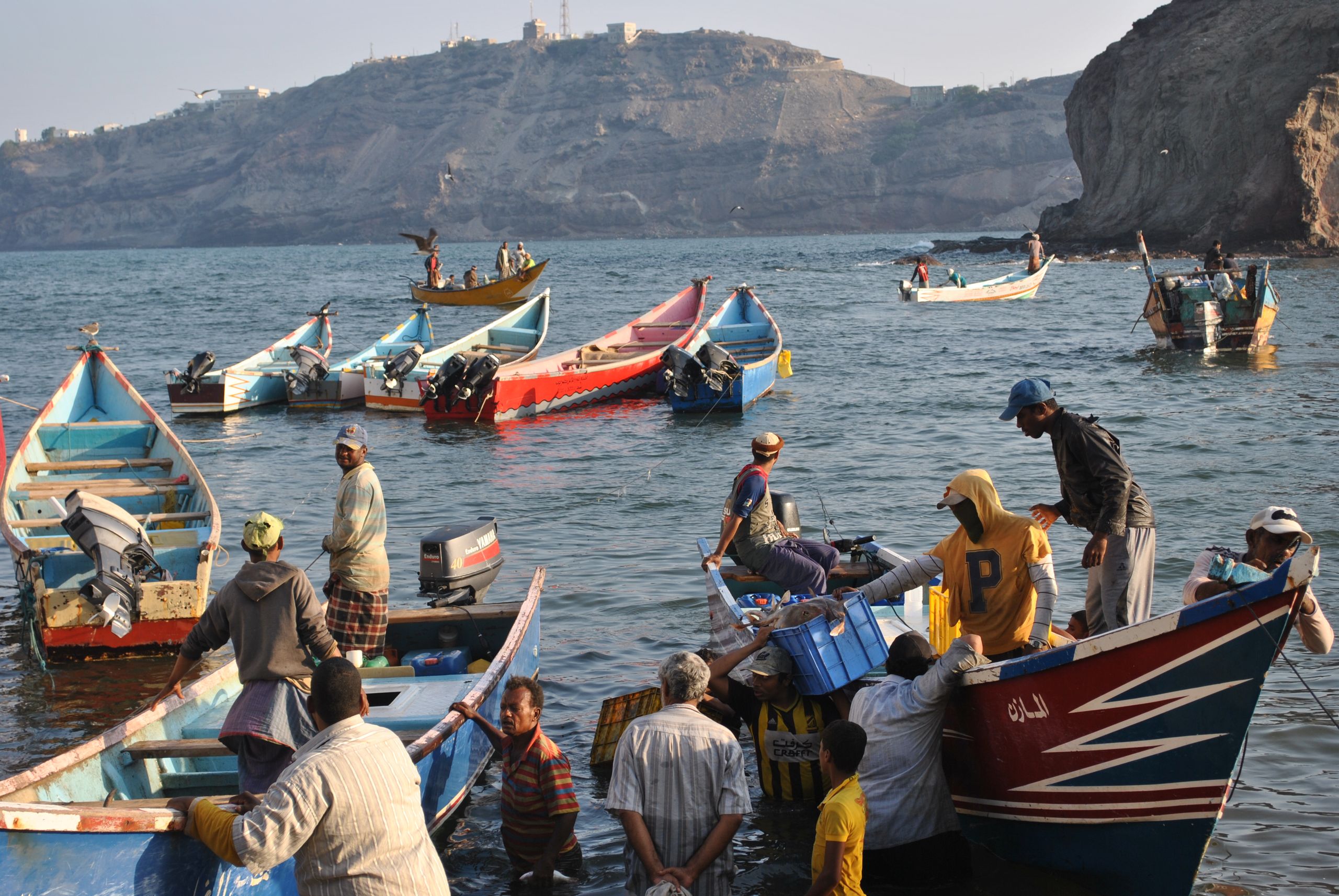 A vibrant scene of fishermen and boats at the coast of Aden, Yemen.