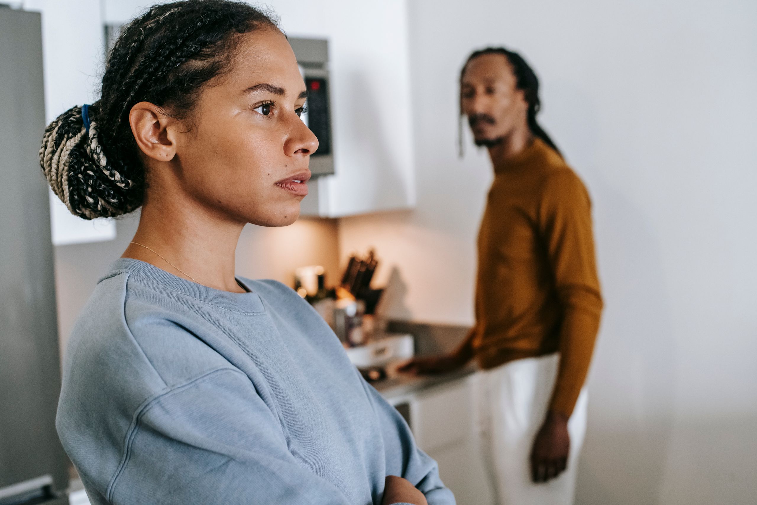 Black lady and guy standing in kitchen at home and having conflict while arguing