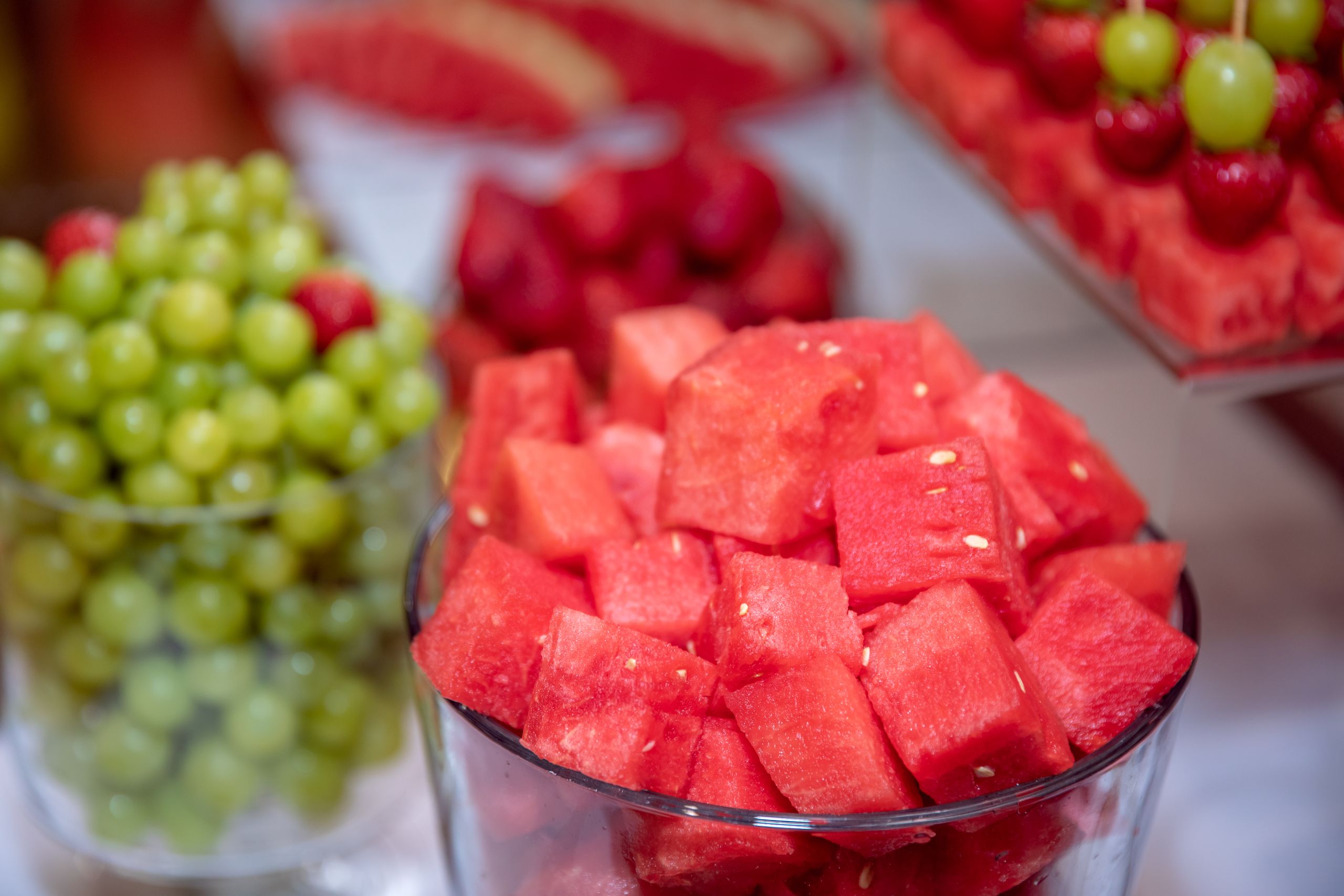 Colorful close-up of watermelon cubes with grapes and strawberries, perfect for summer refreshment.