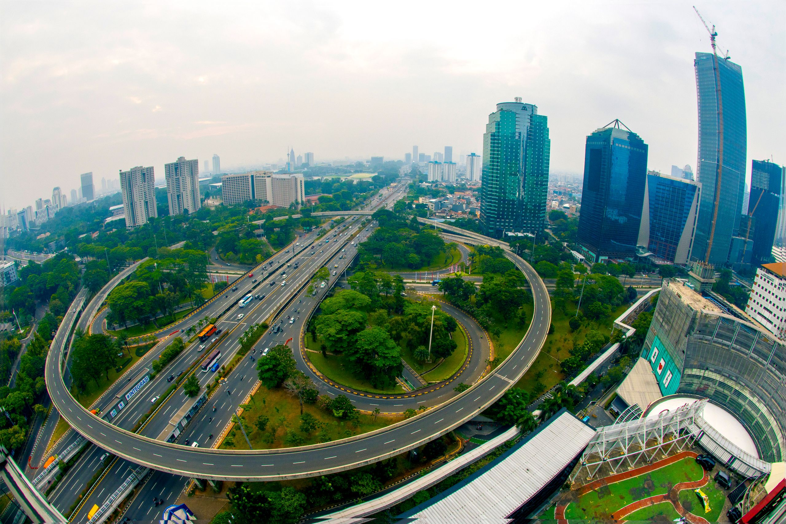 Dynamic aerial shot of Jakarta's skyline showcasing modern skyscrapers and busy highways.
