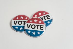 Red, white, and blue voting badges promoting elections on a clean white background.