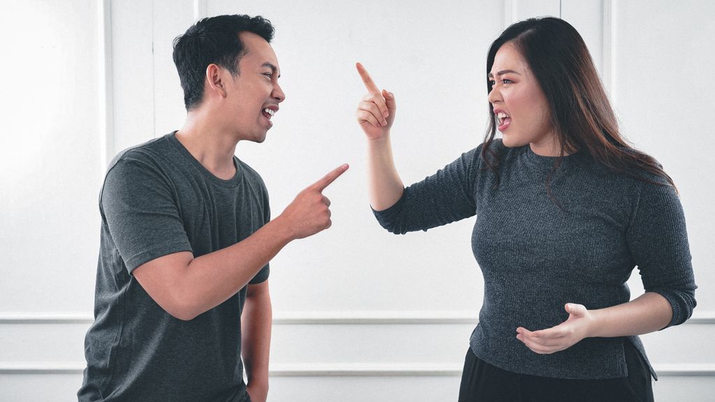 A couple engaged in a heated argument at home, expressing strong emotions.