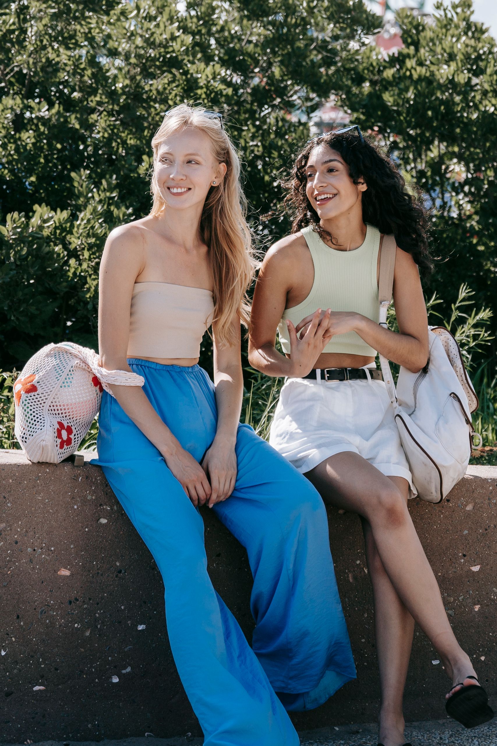 Two women sitting together outdoors, enjoying the sunshine and each other's company.