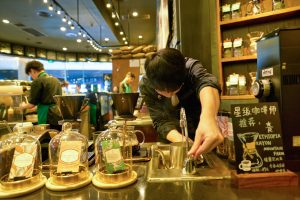 SHENZHEN, CHINA - CIRCA APRIL, 2019: man prepare coffee at Starbucks Coffee in Shenzhen. Starbucks Corporation is an American coffee company and coffeehouse chain.