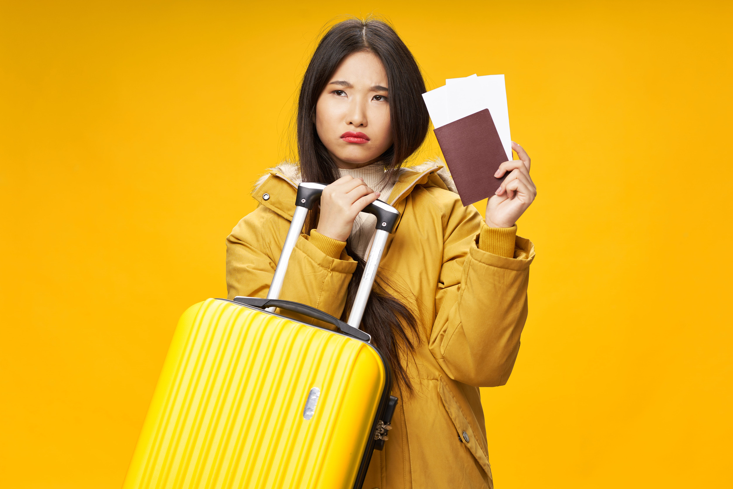 woman with yellow suitcase passport and plane tickets travel vacation airport