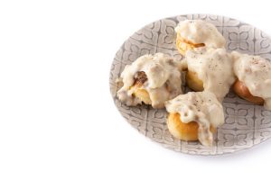 Traditional American biscuits and gravy for breakfast isolated on white background