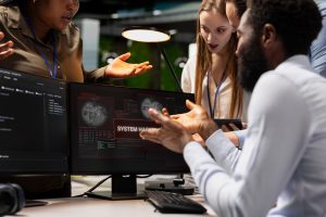 Close up of coworkers helping engineer stop hacker intrusion in office. African american man and staff members colleagues coordinating incident response for network attack