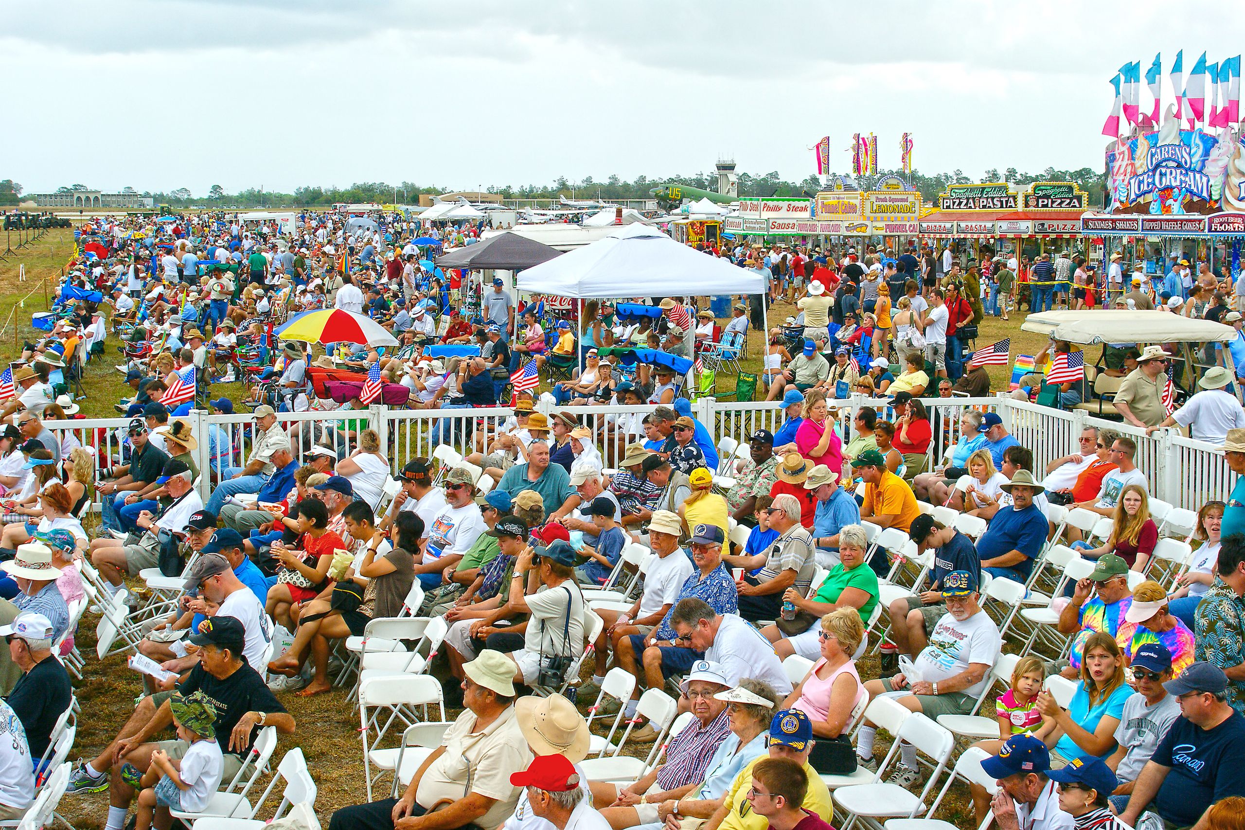 A lively scene of people gathered at an air show in Titusville, Florida, enjoying the festive atmosphere.