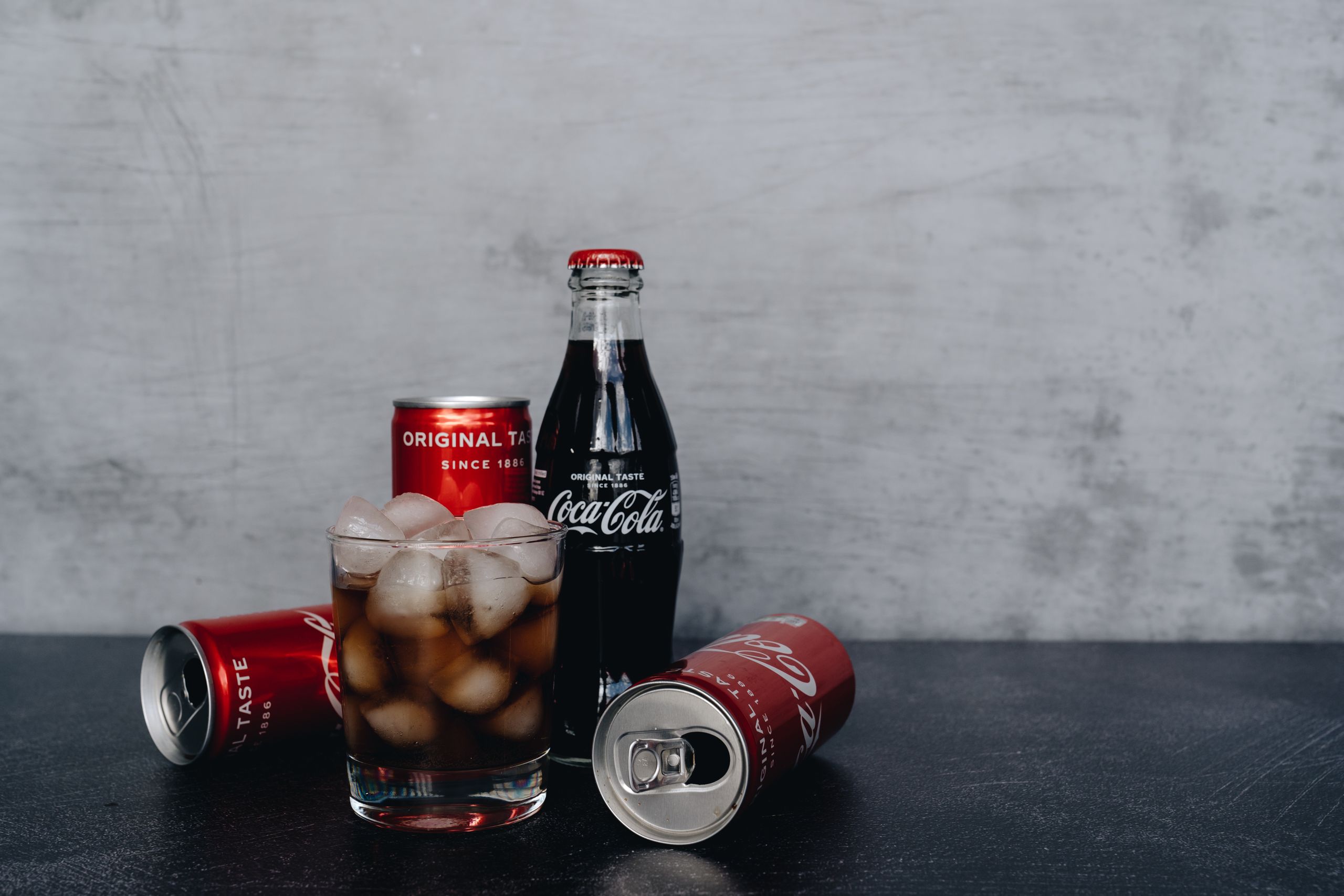 Chilled Coca-Cola bottles and cans with ice, offering a refreshing drink experience.