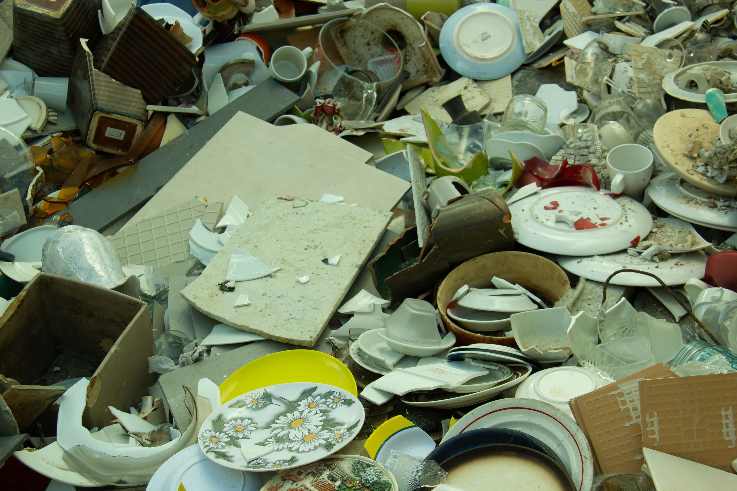 Discarded stack of broken ceramics and glassware in Gent, showcasing waste and recycling.