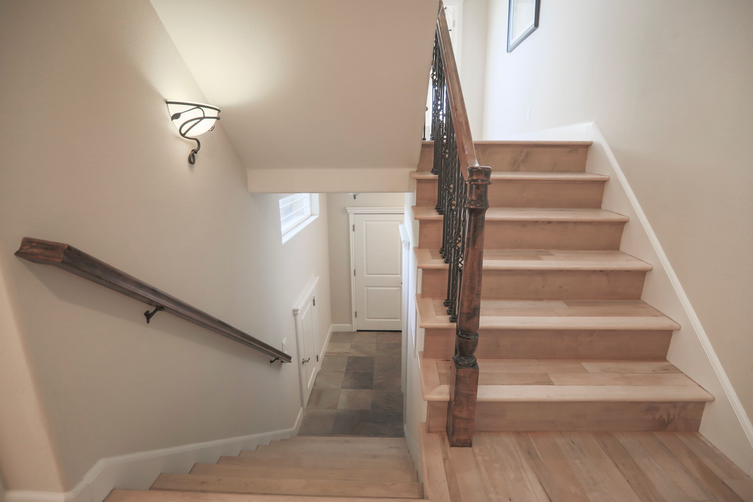 Luxurious wooden staircase with artistic railing in a modern home interior.