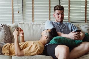 two-men-using-smartphones-and-relaxing-on-a-couch