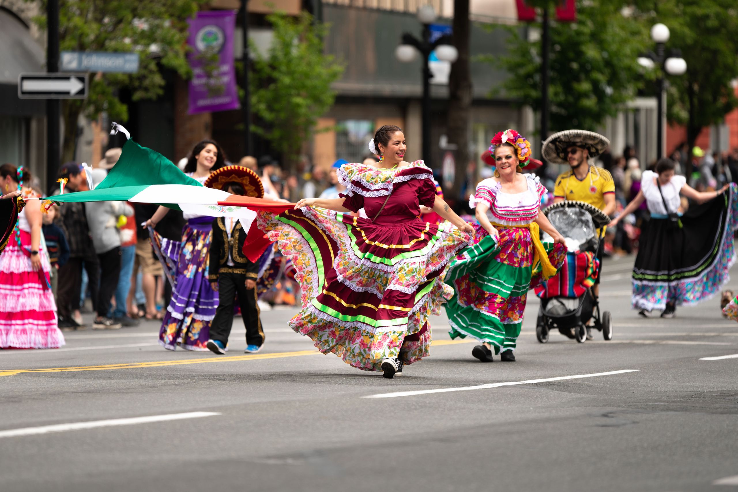 Vibrant Mexican cultural parade with traditional dresses in Victoria, BC streets.