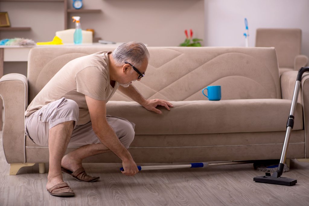 Old man doing housework at home