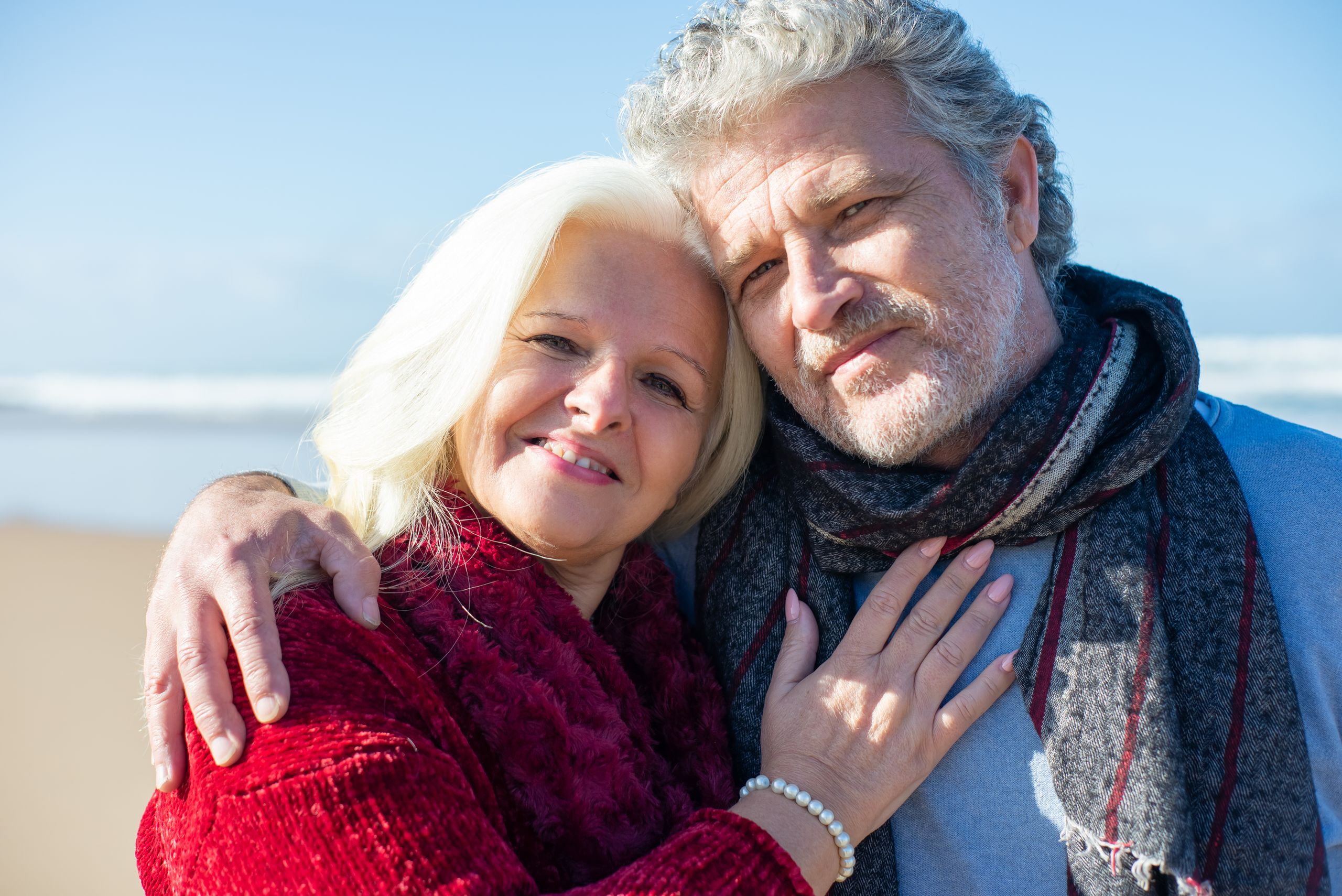 Elderly couple sharing a joyful moment by the beach in Portugal, showcasing love and togetherness.