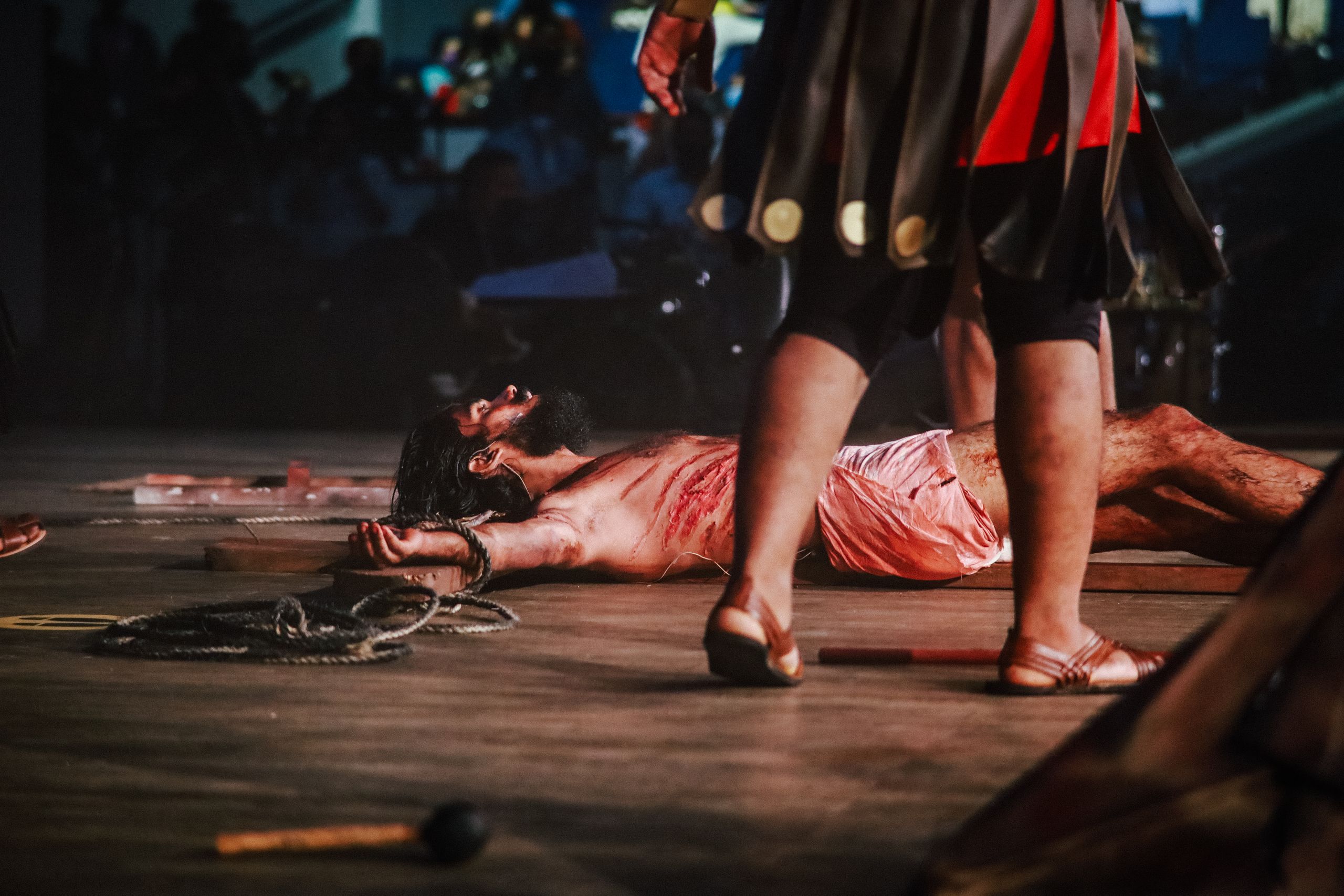 Emotional depiction of a religious play scene with actors performing a crucifixion.