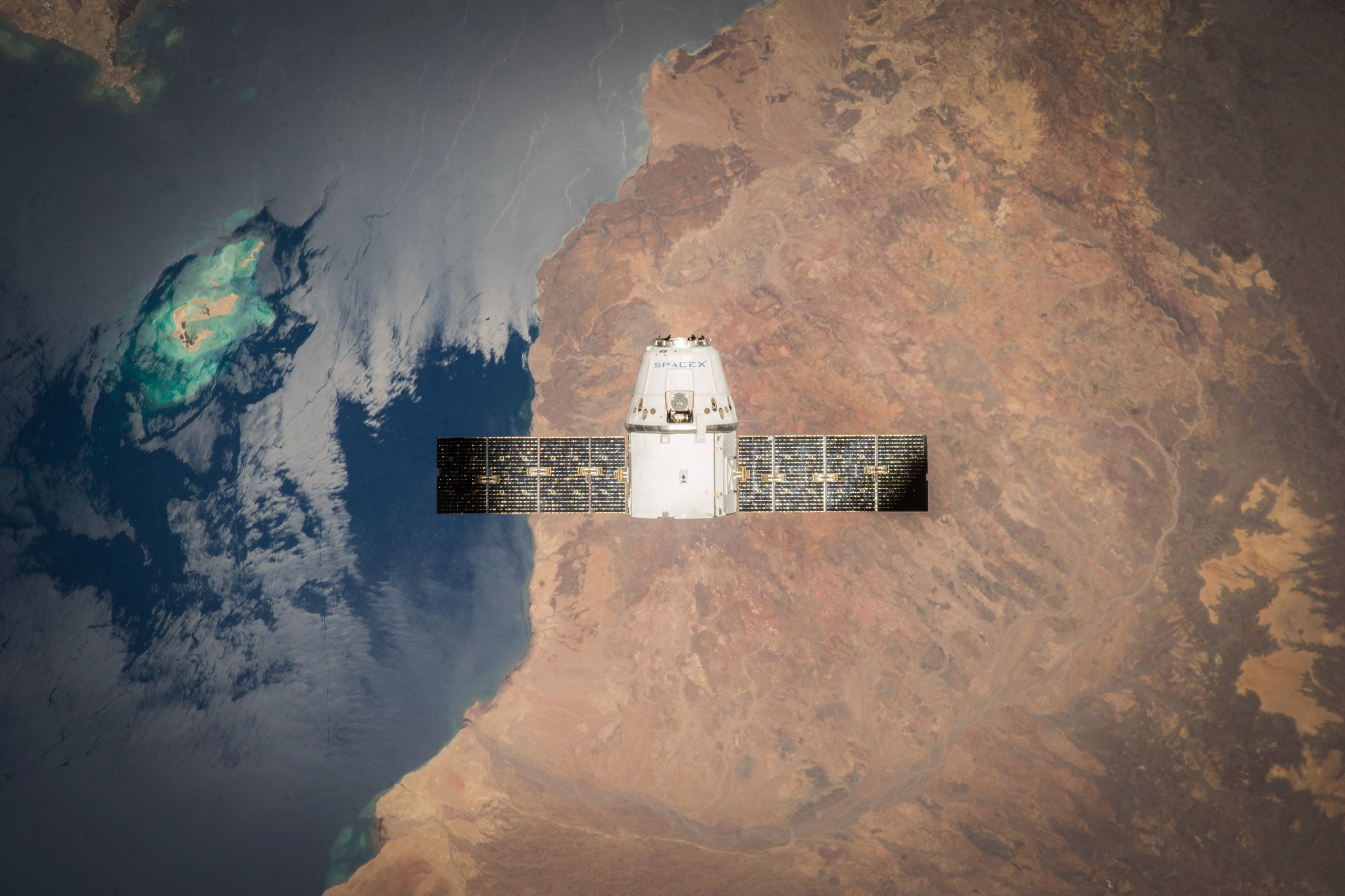 Satellite in orbit with detailed view of Earth and ocean below.